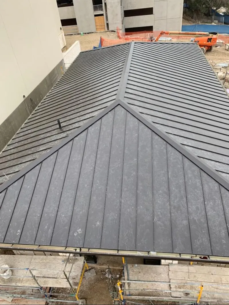 Commercial metal roof construction with crane equipment in Cloverleaf
